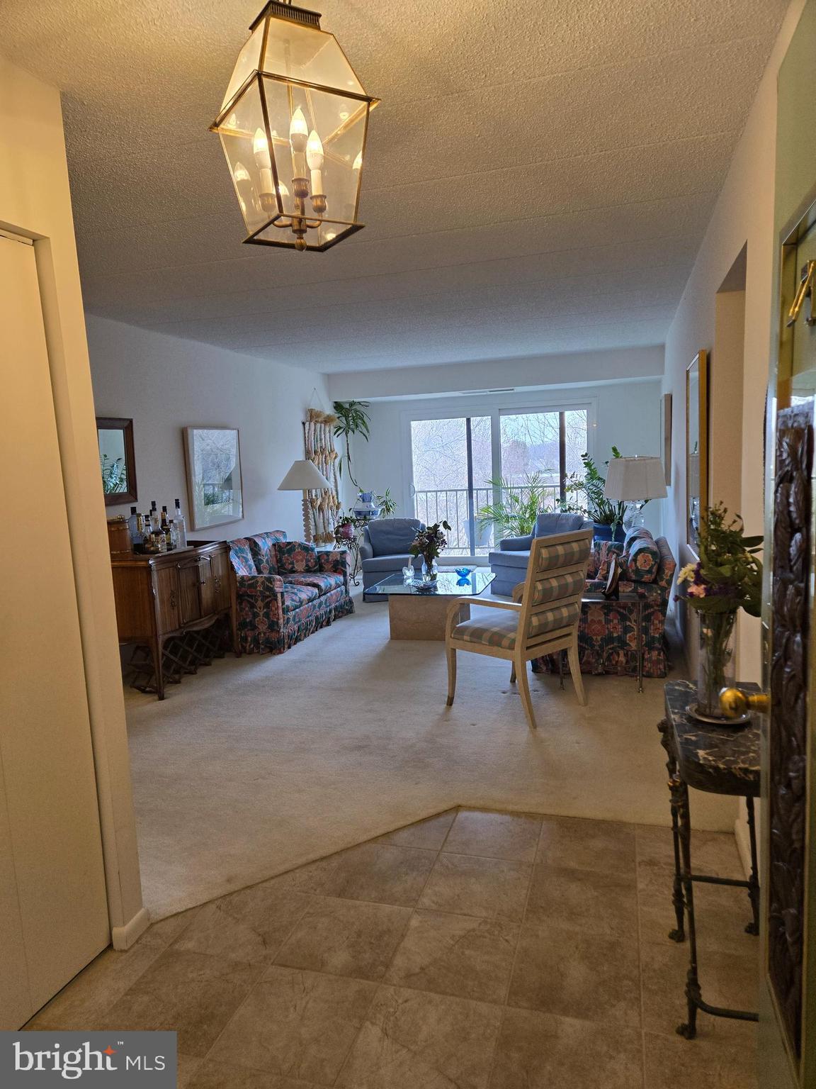 1000 Putnam Boulevard, Unit 603 Wallingford, PA 19086 - Photo 9 of 44 a living room with furniture and a chandelier