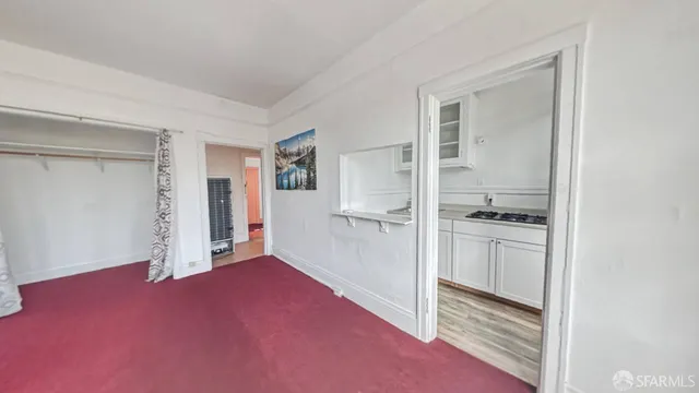 a view of empty room with kitchen