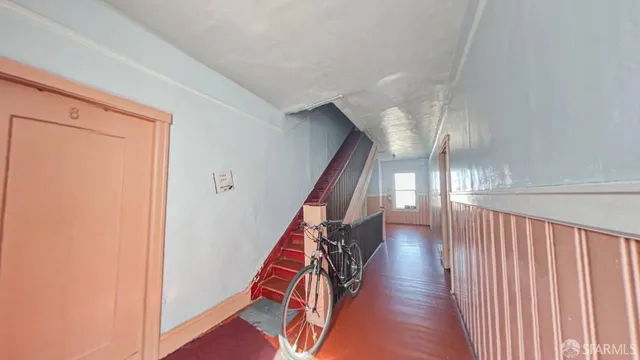 a view of a hallway with wooden floor and stairs