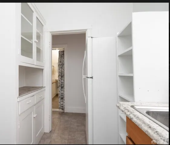 a kitchen with white cabinets and refrigerator