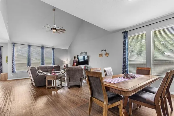 a dining room with furniture a chandelier and wooden floor
