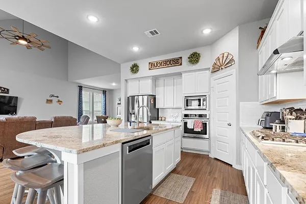 a view of kitchen with stainless steel appliances refrigerator stove microwave and cabinets