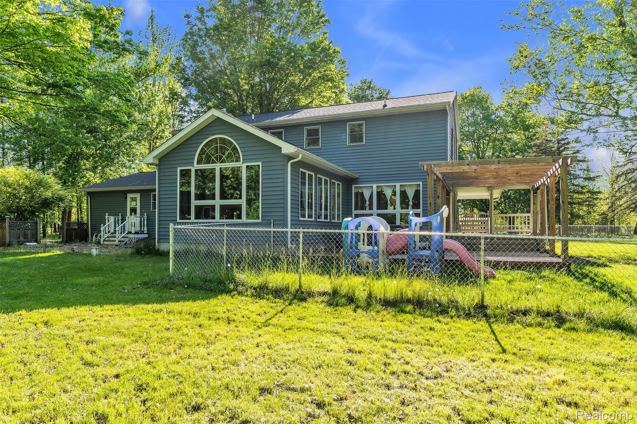 1345 Ives Road Mason, MI 48854 - Photo 60 of 92 Rear view of house featuring a fenced backyard and a wooden deck