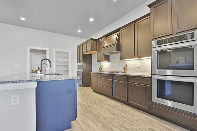 a kitchen with granite countertop a sink stainless steel appliances and cabinets