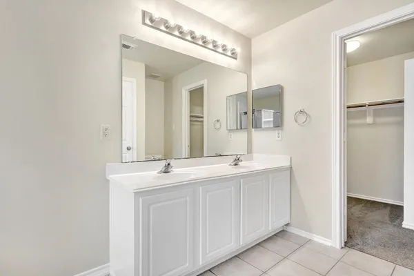 a spacious bathroom with a double vanity sink and a mirror