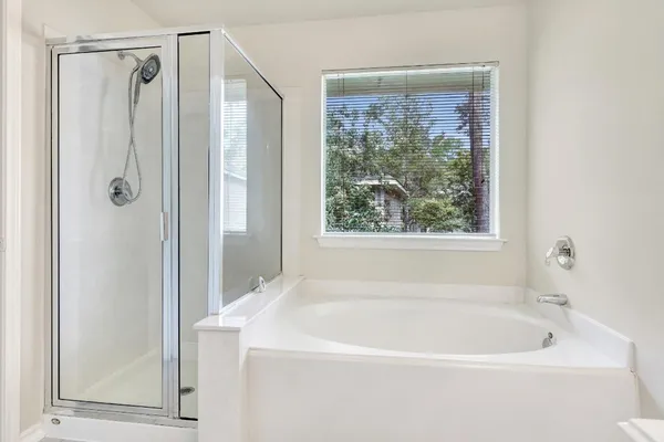 a white bath tub sitting next to a shower