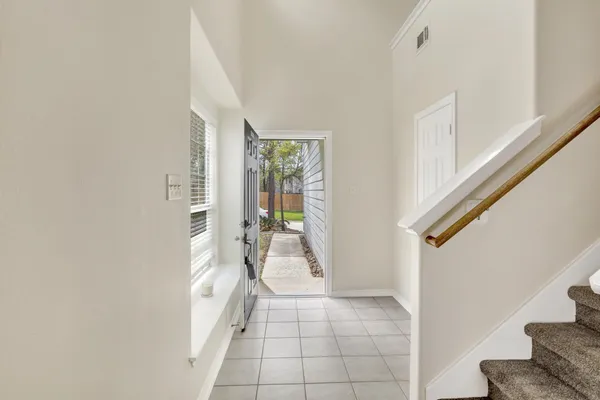 a hallway with white doors wooden floor and stairs