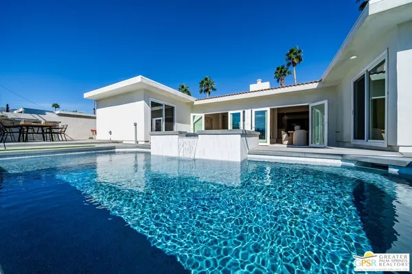a view of a house with swimming pool and sitting area