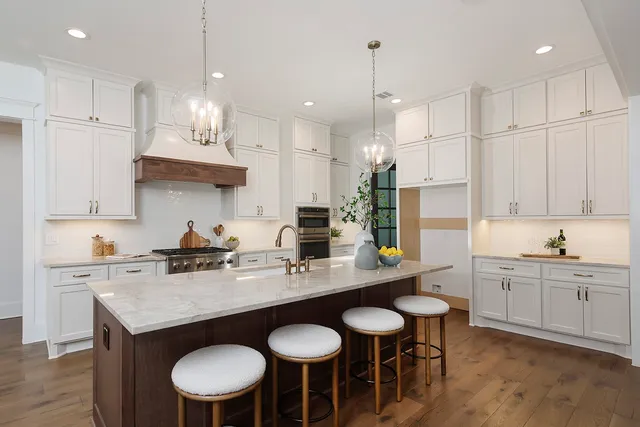 a kitchen with kitchen island granite countertop a sink a counter space appliances and cabinets