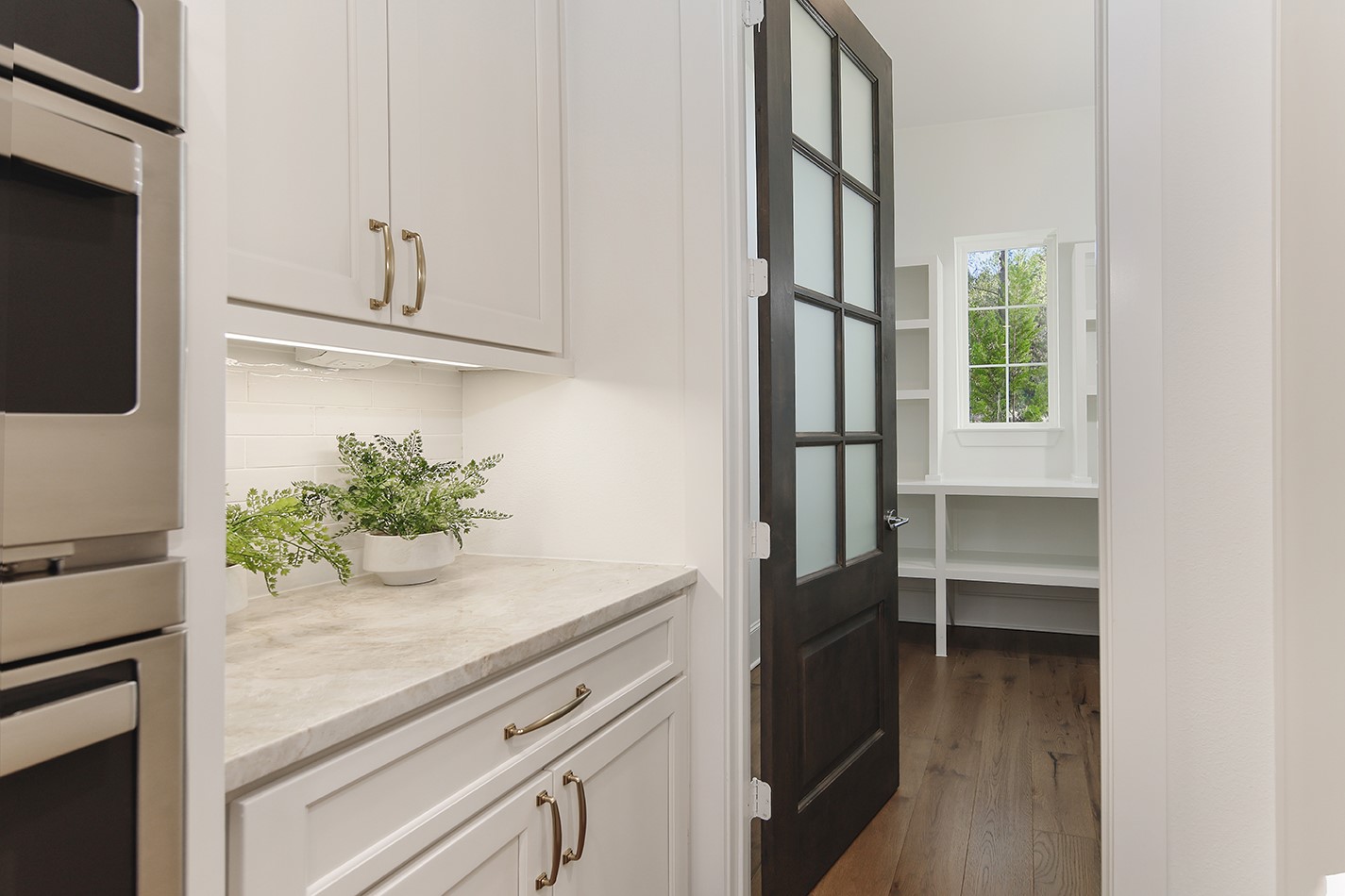 630 Lonestar Road Huntsville, TX 77340 - Photo 20 of 48 a kitchen with white cabinets and a potted plant