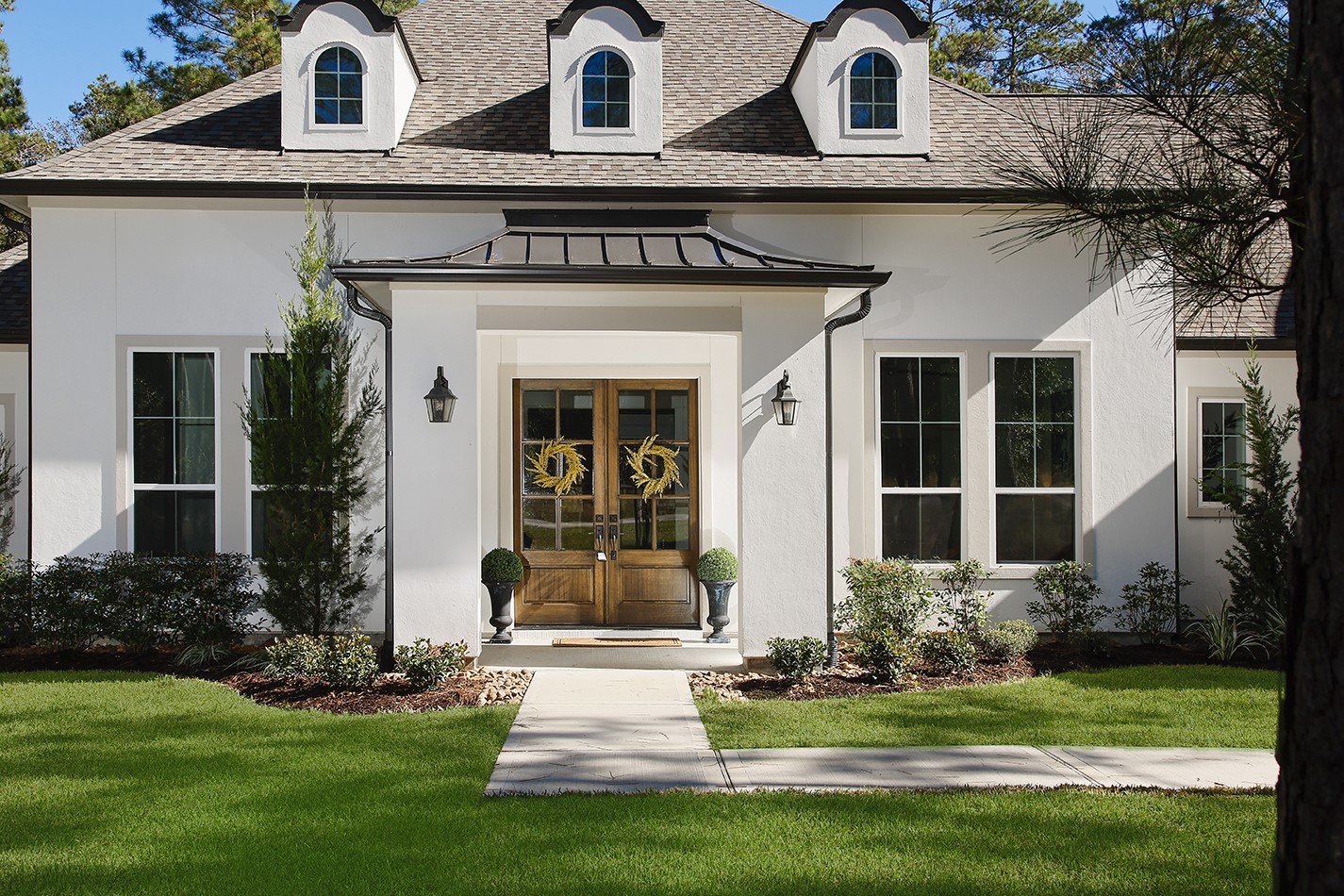 630 Lonestar Road Huntsville, TX 77340 - Photo 3 of 48 Lovely green lawn, landscaped beds, elegant stucco facade and stunning front doors will not disappoint when you step inside.