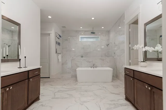 a view of a white house next to a yard with big trees