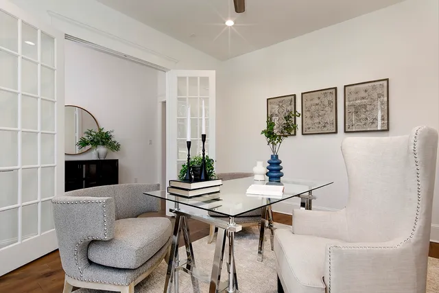 a kitchen with stainless steel appliances granite countertop a stove a refrigerator a kitchen island a dining table and chairs with wooden floor