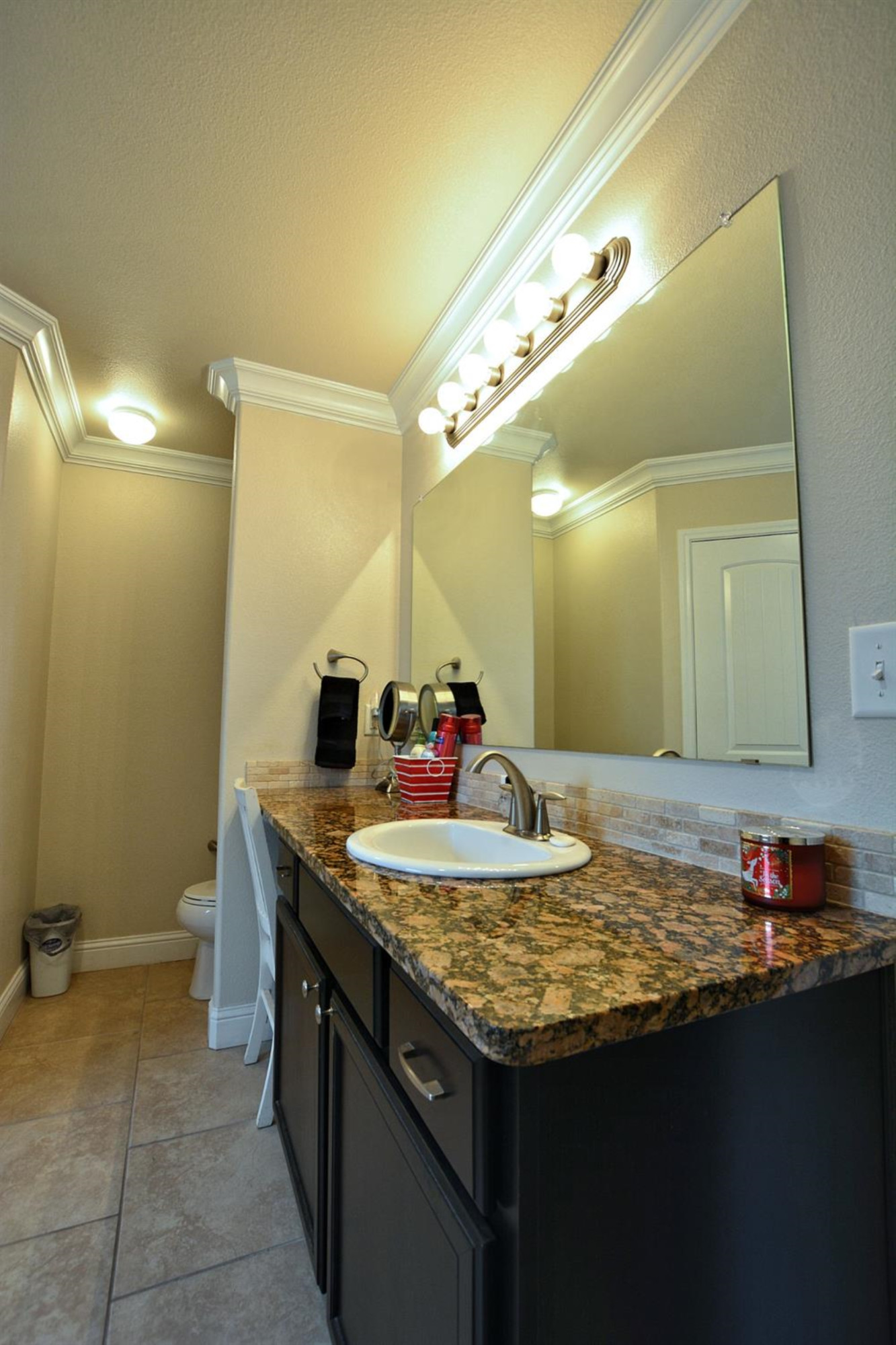 3703 Rochester Avenue Lubbock, TX 79407 - Photo 14 of 20 a bathroom with a granite countertop sink and a mirror