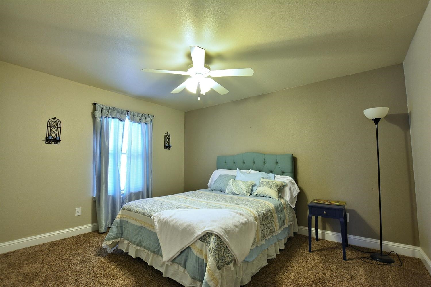 3703 Rochester Avenue Lubbock, TX 79407 - Photo 15 of 20 a bedroom with a bed and a chandelier