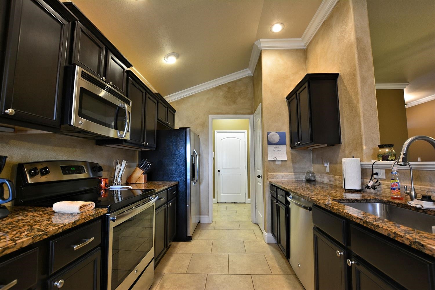 3703 Rochester Avenue Lubbock, TX 79407 - Photo 6 of 20 a kitchen with stainless steel appliances granite countertop a stove a sink and a microwave