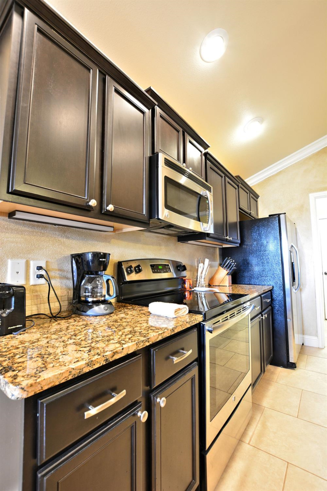3703 Rochester Avenue Lubbock, TX 79407 - Photo 7 of 20 a kitchen with stainless steel appliances granite countertop a stove a sink and a microwave