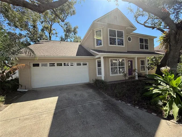a view of a white house with large windows and a small yard