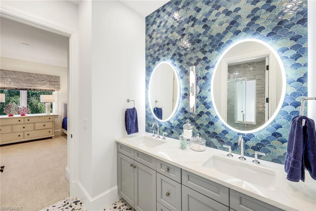 2106 Modena Court Naples, FL 34105 - Photo 32 of 42 a en suite bathroom with a double vanity sink and a mirror