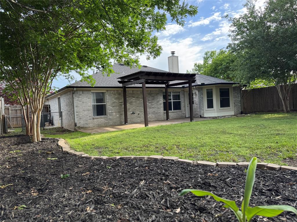 6241 Peach Tree Drive Midlothian, TX 76065 - Photo 2 of 19 Expansive backyard featuring a manicured lawn, a large concrete patio with a dark wood pergola, and mature trees
