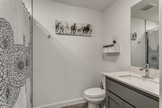 a bathroom with a granite countertop sink toilet and a mirror