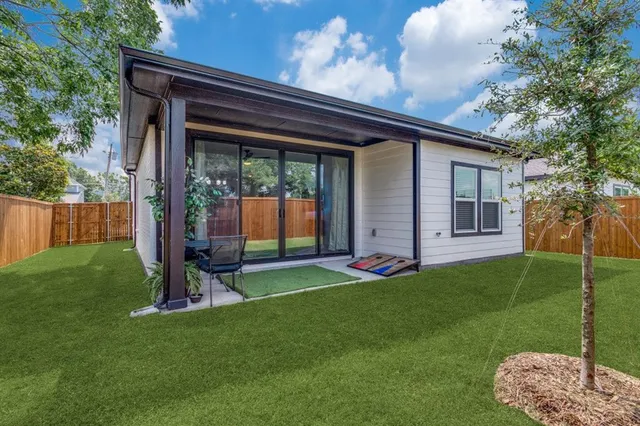 a view of an house with backyard and a tree
