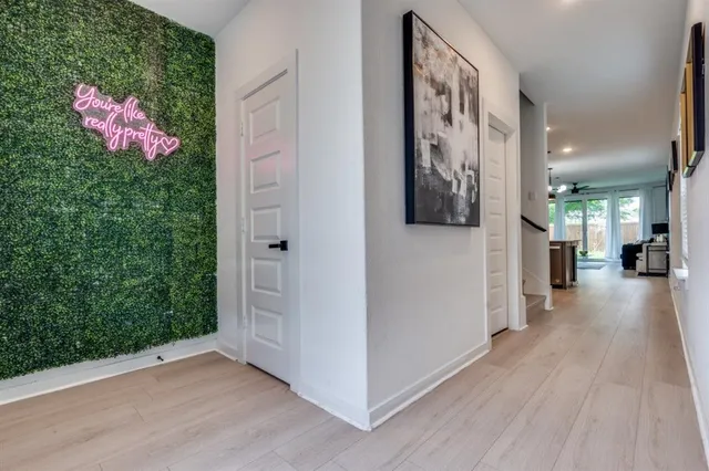 a hallway with wooden floor and cabinet
