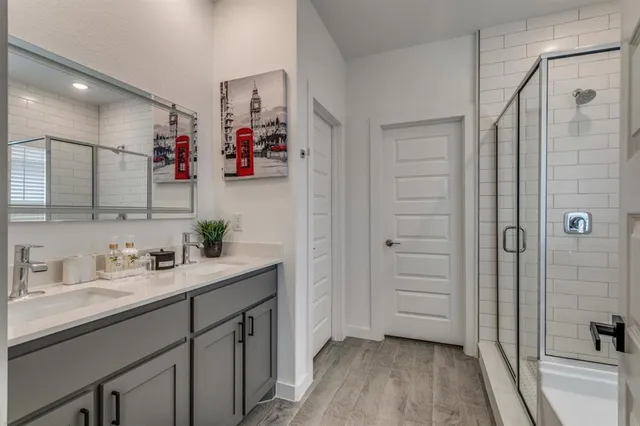 a bathroom with a double vanity sink mirror and shower