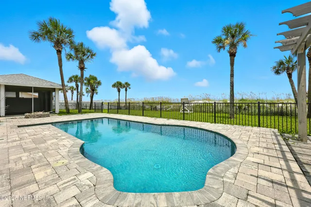a view of a swimming pool with a lawn chairs under an umbrella