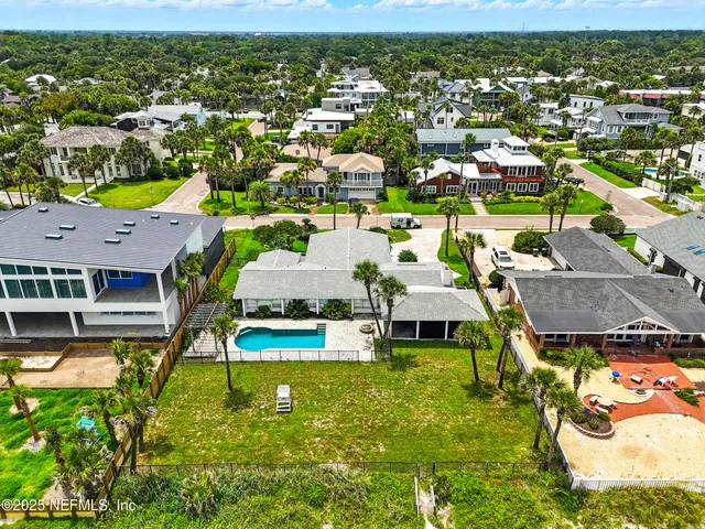 an aerial view of residential houses with outdoor space and swimming pool