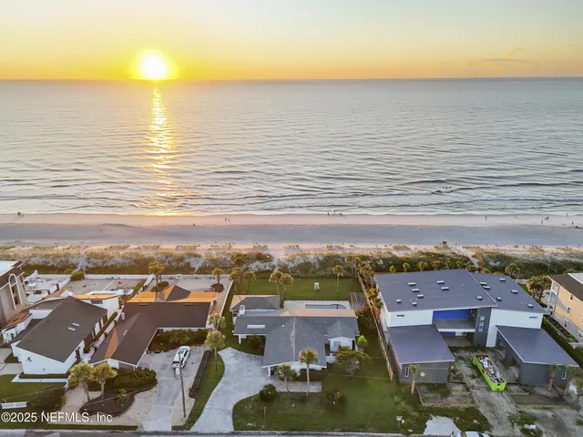 an aerial view of residential building with ocean view in back