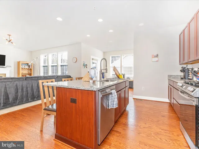 a open kitchen with stainless steel appliances granite countertop a stove and a sink