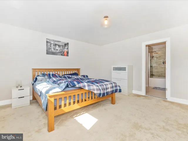 a bedroom with a bed and painting on the wall