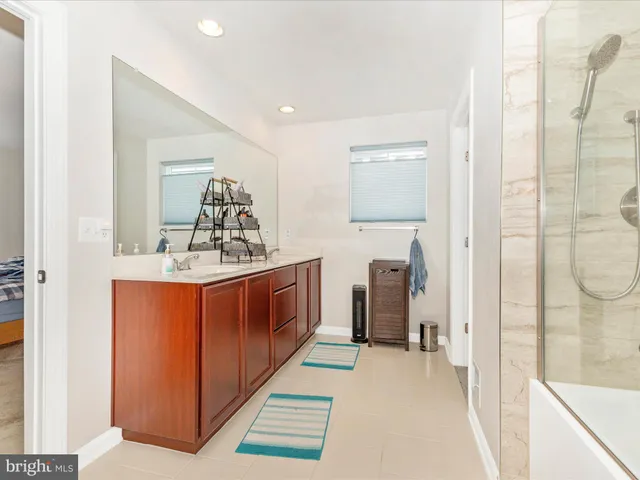 a en suite bathroom with a sink mirror and shower