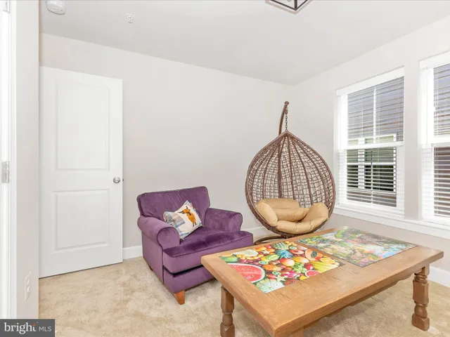 a living room with furniture a window and a potted plant