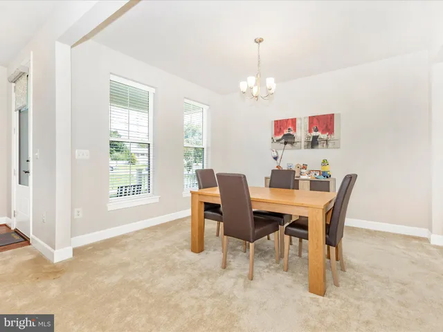 a view of a dining room with furniture a chandelier and a window