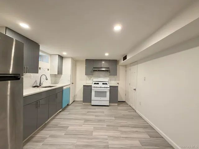 a large kitchen with a stove top oven and sink