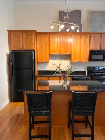 a kitchen with stainless steel appliances a table chairs and a refrigerator