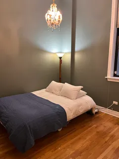 a bedroom with a bed and a chandelier