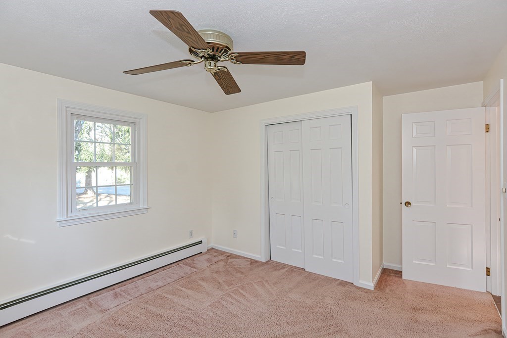 325 Spring Street Wrentham, MA 02093 - Photo 29 of 42 a view of a livingroom with a ceiling fan & windows