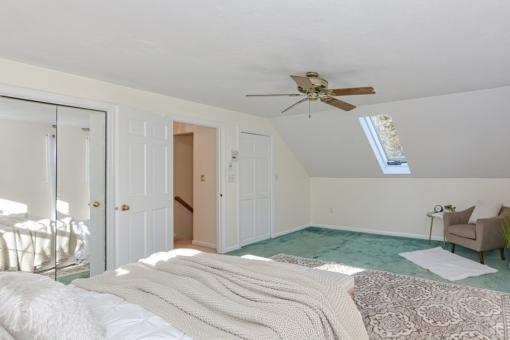 325 Spring Street Wrentham, MA 02093 - Photo 36 of 42 a bedroom with a bed and a chandelier