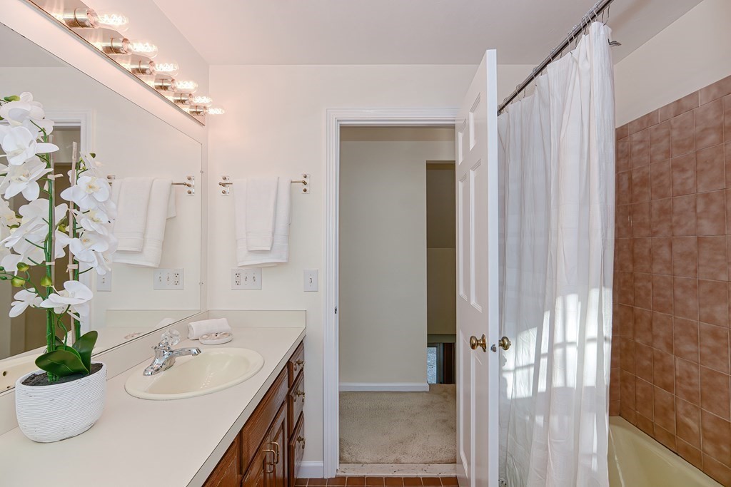 325 Spring Street Wrentham, MA 02093 - Photo 39 of 42 a bathroom with a sink a faucet a mirror and a bathtub