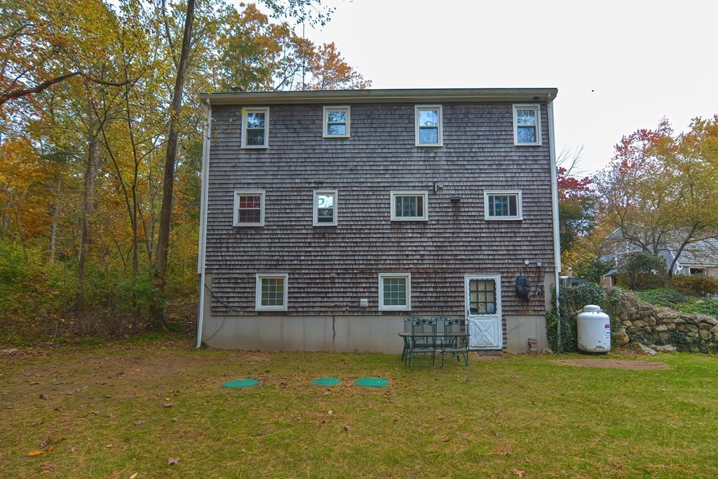325 Spring Street Wrentham, MA 02093 - Photo 6 of 42 a brick house that has a small yard and large trees