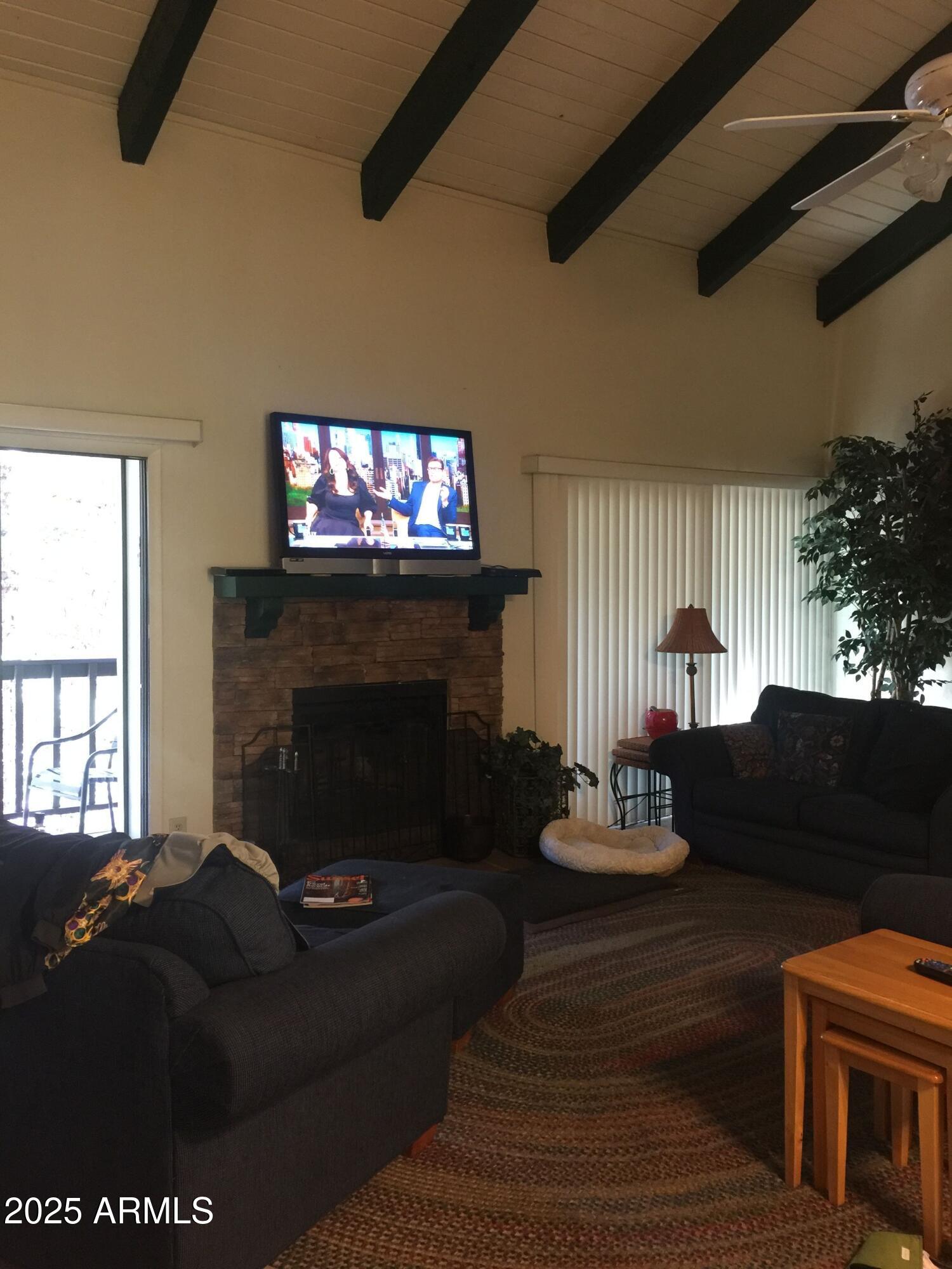 4479 Resort Loop, Unit A21 Pinetop, AZ 85935 - Photo 4 of 12 a living room with furniture a fireplace and a flat screen tv