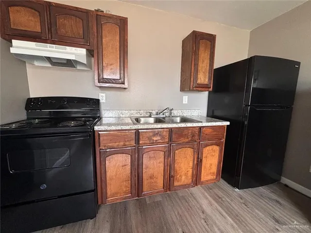 a kitchen with stainless steel appliances granite countertop a refrigerator stove and sink