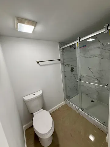 an empty room with chandelier fan and windows