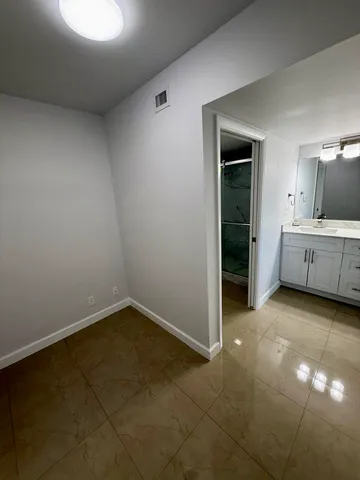 an empty room with windows and ceiling fan