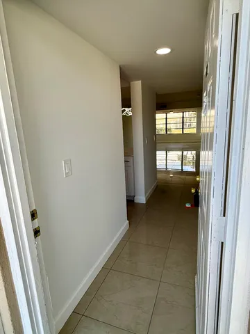 a view of a kitchen with kitchen island a sink stainless steel appliances and cabinets