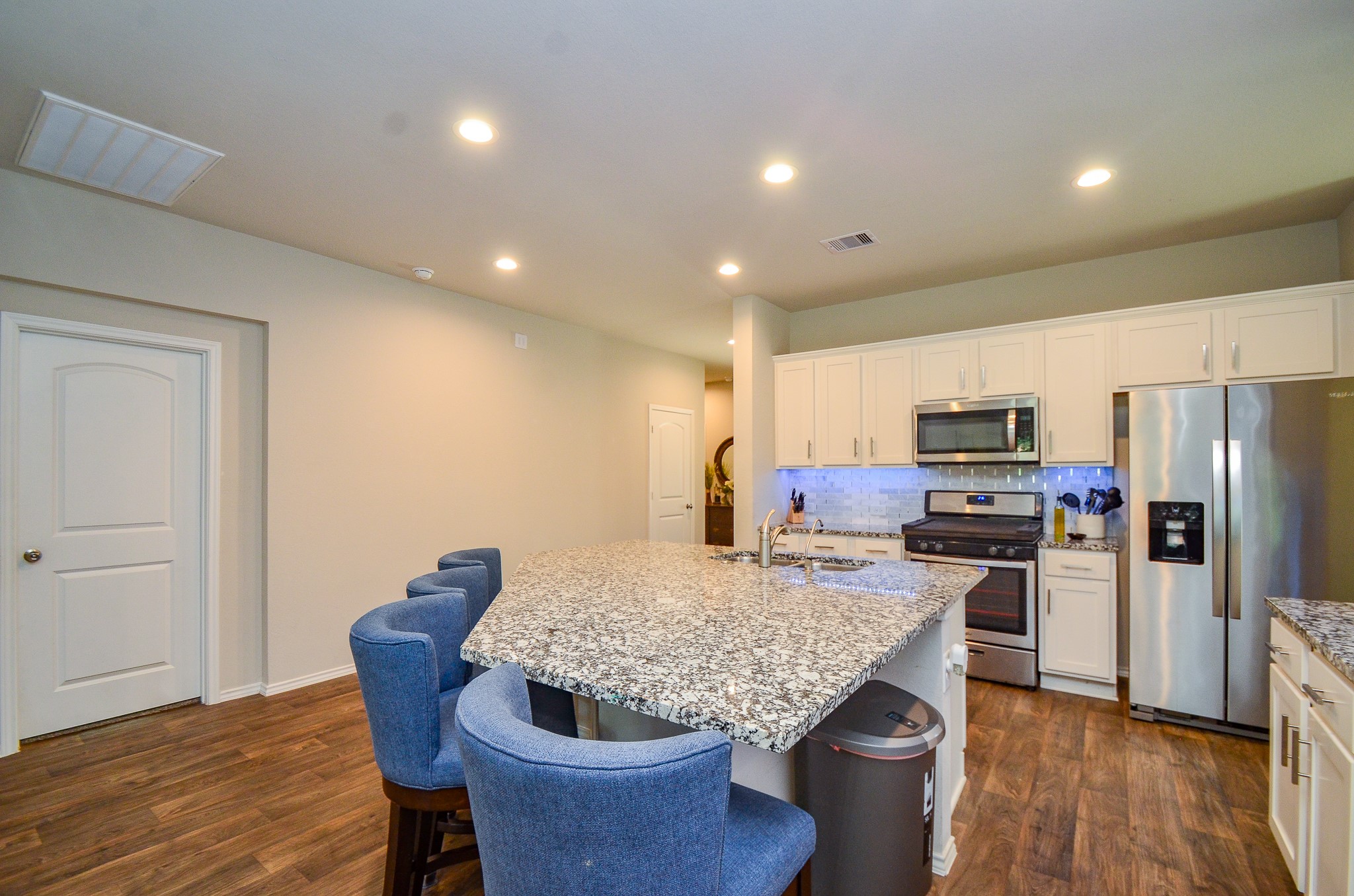 3810 Willow Valley Conroe, TX 77301 - Photo 7 of 38 a kitchen with granite countertop kitchen island wooden floor and refrigerator