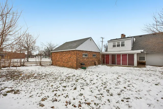 a front view of a house with a yard covered in snow